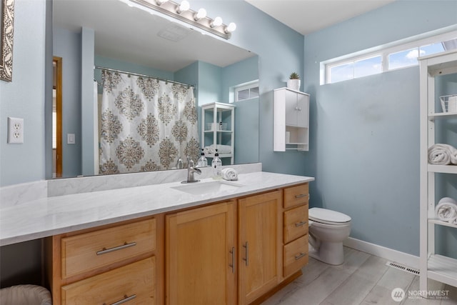 full bathroom with toilet, vanity, and a shower with shower curtain