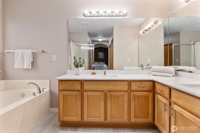 full bathroom with double vanity, a stall shower, a garden tub, and connected bathroom