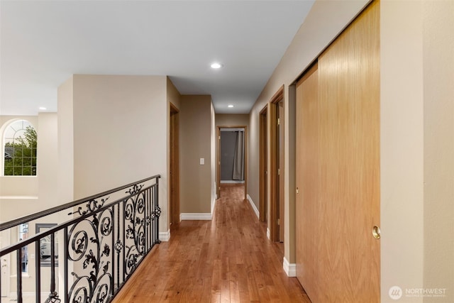 hall with light wood finished floors, recessed lighting, and baseboards