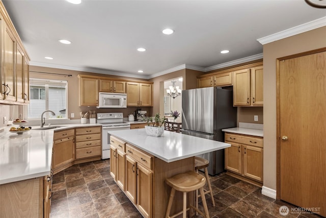 kitchen featuring white appliances, a sink, dark stone finish flooring, a center island, and light countertops
