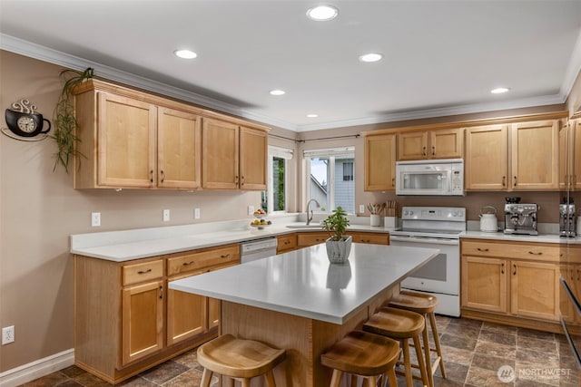 kitchen featuring white appliances, a breakfast bar, ornamental molding, light countertops, and stone finish floors