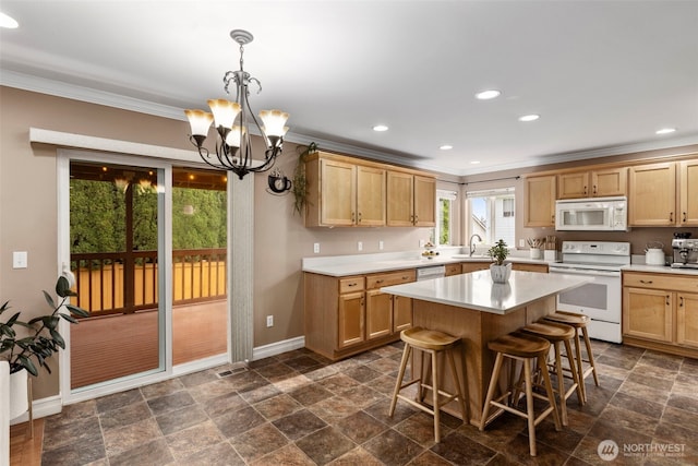 kitchen with white appliances, crown molding, a chandelier, dark stone finish flooring, and baseboards