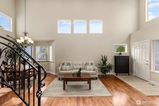entrance foyer with a towering ceiling, a chandelier, plenty of natural light, and baseboards