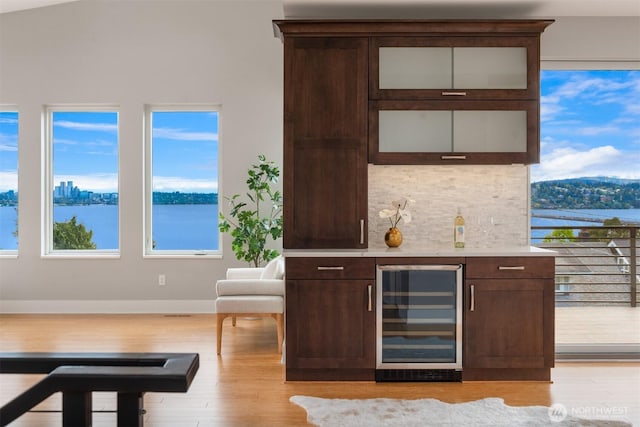 815 33rd Ave S, Seattle, WA 98144 - indoor dry bar with beverage cooler, light wood finished floors, backsplash, baseboards, and a water view