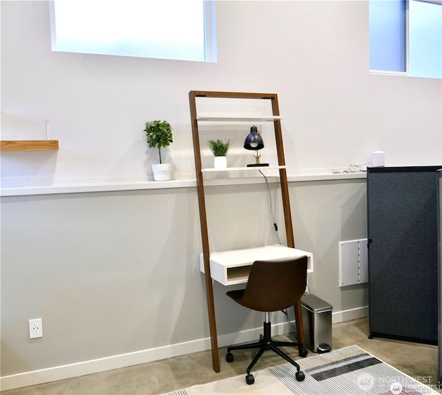 office with concrete floors and baseboards
