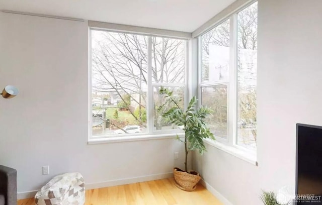 sitting room featuring plenty of natural light, wood finished floors, and baseboards