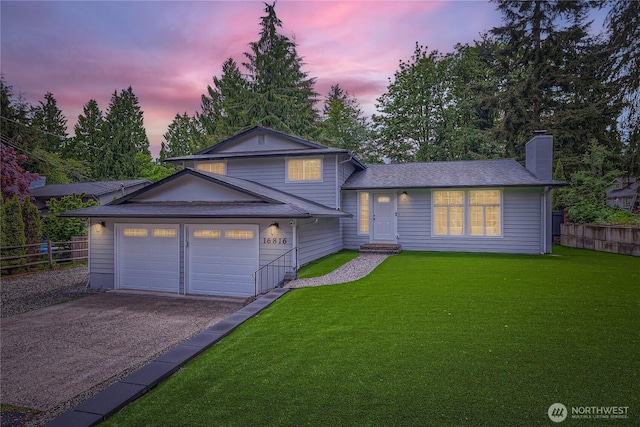 split level home featuring driveway, a chimney, and a garage