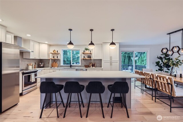 kitchen with appliances with stainless steel finishes, open shelves, white cabinetry, plenty of natural light, and recessed lighting