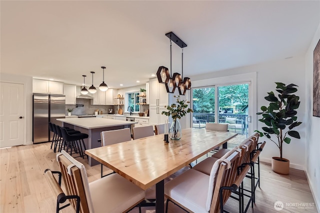 dining area featuring light wood finished floors, recessed lighting, and baseboards