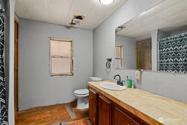 1410 Stone Rd, Yakima, WA 98908 - bathroom with wood finished floors, toilet, vanity, and a shower with shower curtain