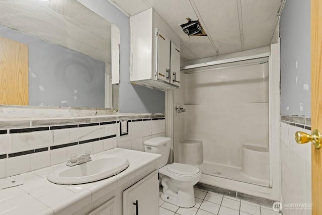 1410 Stone Rd, Yakima, WA 98908 - full bath featuring tile walls, a shower stall, tile patterned flooring, toilet, and vanity