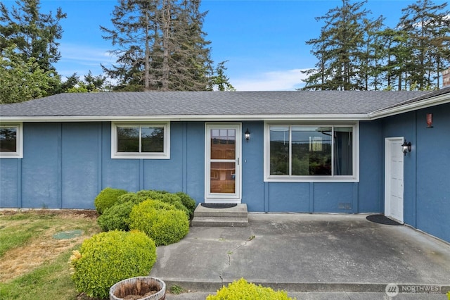 property entrance with roof with shingles and stucco siding