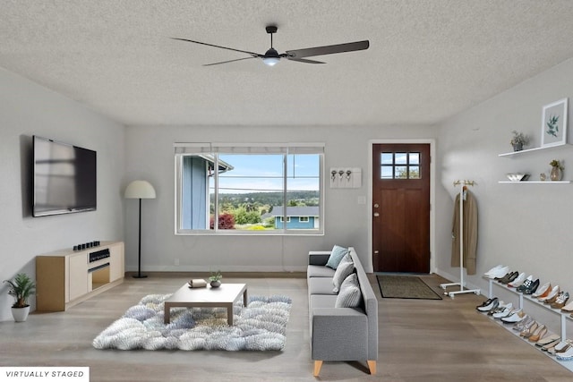 1310 Swantown Rd, Oak Harbor, WA 98277 - living area featuring a textured ceiling, light wood-style floors, ceiling fan, and baseboards