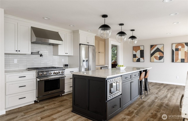 kitchen featuring stainless steel appliances, wall chimney exhaust hood, white cabinets, decorative backsplash, and dark wood-style floors