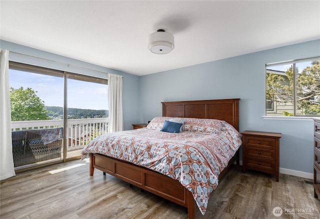 bedroom featuring access to outside and wood finished floors