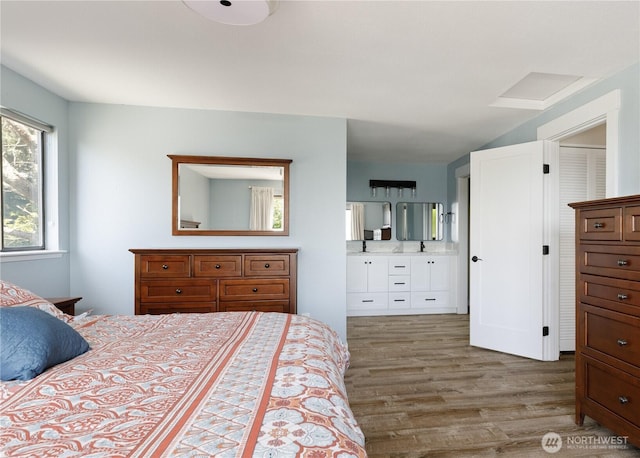 bedroom with wood finished floors and ensuite bathroom