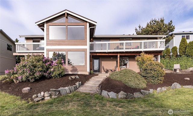 view of front of house featuring a balcony and a front yard