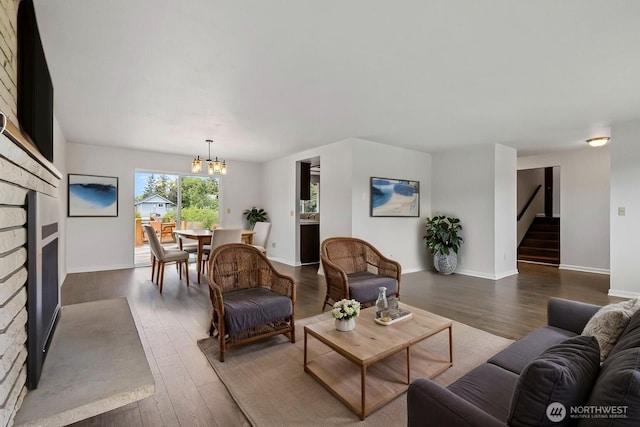 3812 R Ave, Anacortes, WA 98221 - living room with dark wood-type flooring, a fireplace, stairs, a chandelier, and baseboards