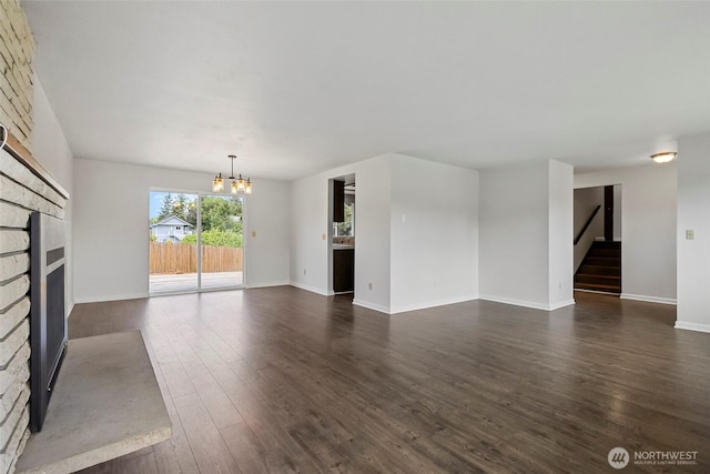 3812 R Ave, Anacortes, WA 98221 - unfurnished living room featuring a fireplace, a chandelier, dark wood-style flooring, baseboards, and stairs
