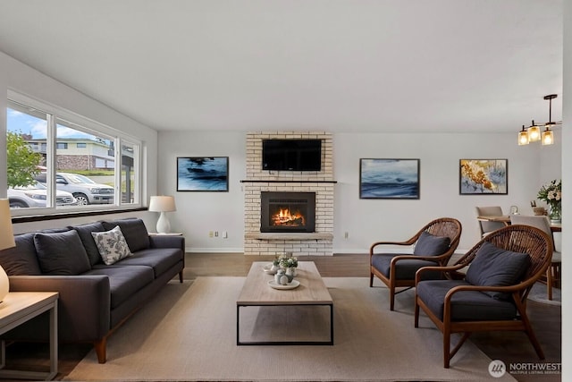 3812 R Ave, Anacortes, WA 98221 - living room featuring a fireplace, baseboards, wood finished floors, and a chandelier