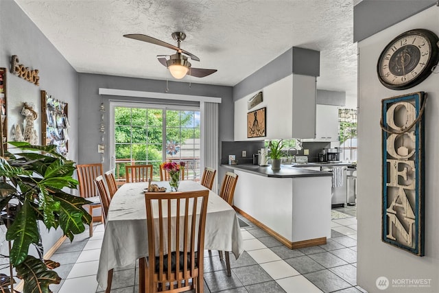 dining area with ceiling fan, light tile patterned floors, and a textured ceiling