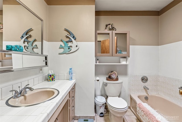full bath with a garden tub, toilet, vanity, and tile patterned floors