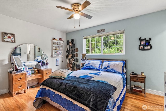 bedroom featuring wood finished floors, baseboards, and a ceiling fan