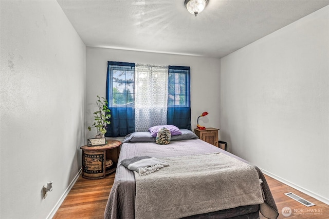 bedroom with wood finished floors and baseboards