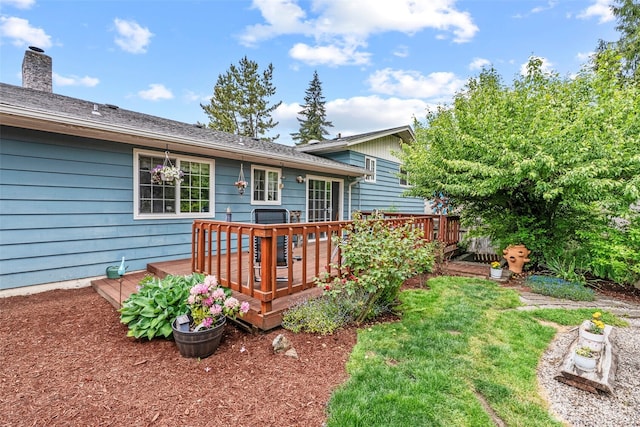 rear view of property featuring a deck and a yard