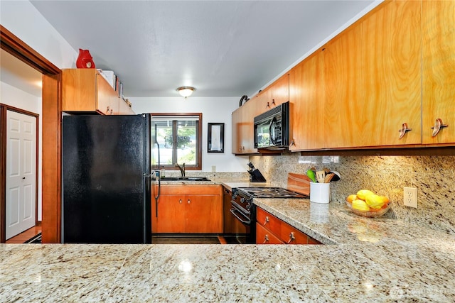 10 Olympic Pl Unit 10, Port Ludlow, WA 98365 - kitchen with black appliances, a sink, decorative backsplash, light stone counters, and wood finished floors