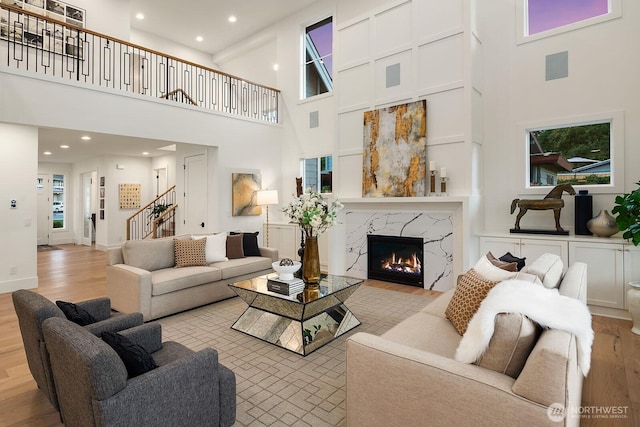 3976 154th Ave SE, Bellevue, WA 98006 - living area with a high ceiling, light wood finished floors, stairs, a high end fireplace, and recessed lighting