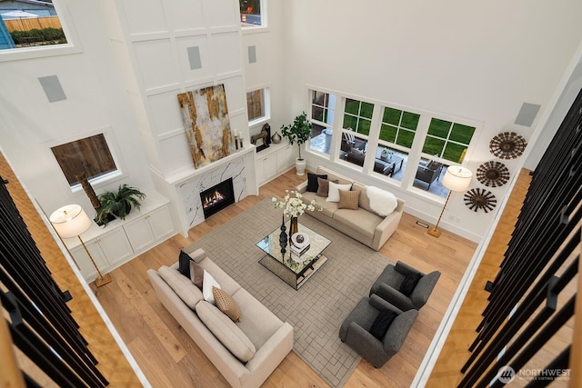 3976 154th Ave SE, Bellevue, WA 98006 - living area with a towering ceiling, light wood-type flooring, a high end fireplace, healthy amount of natural light, and baseboards