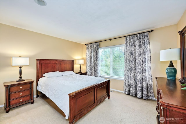 bedroom with light colored carpet and baseboards