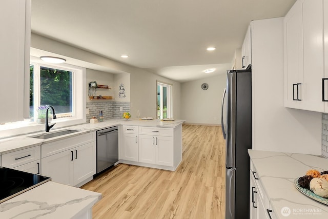 9630 SE Driftwood Dr, Port Orchard, WA 98367 - kitchen with stainless steel appliances, a sink, white cabinets, light wood-style floors, and recessed lighting