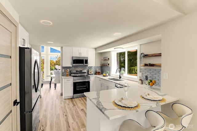 9630 SE Driftwood Dr, Port Orchard, WA 98367 - kitchen with appliances with stainless steel finishes, a sink, open shelves, and a peninsula