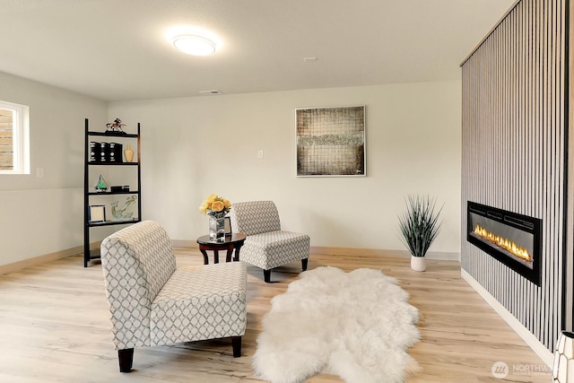 9630 SE Driftwood Dr, Port Orchard, WA 98367 - living area with wood finished floors, a glass covered fireplace, and baseboards