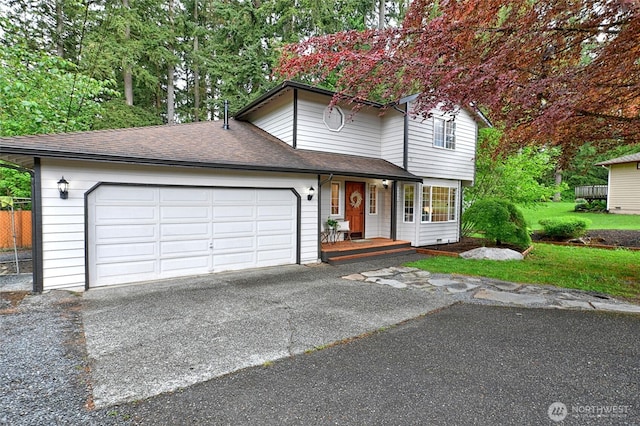 view of front of property with roof with shingles, driveway, an attached garage, and a front lawn