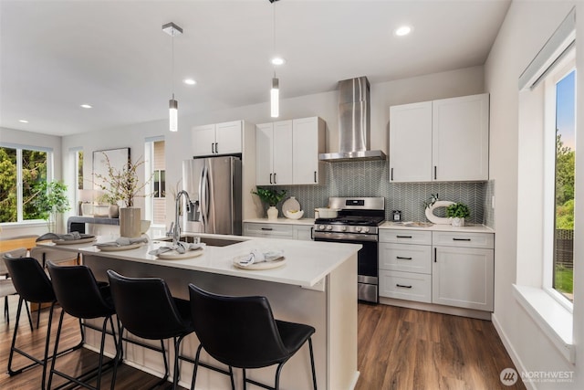 5126 S Creston St, Seattle, WA 98178 - kitchen with stainless steel appliances, wall chimney exhaust hood, a sink, a breakfast bar area, and plenty of natural light