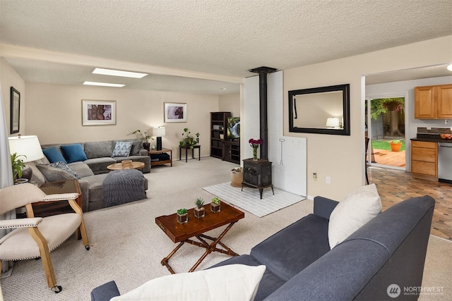 living room featuring a wood stove, light colored carpet, and a textured ceiling