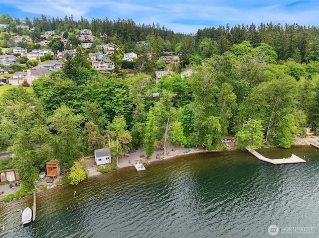aerial view of property's location with a large body of water, a heavily wooded area, and nearby suburban area