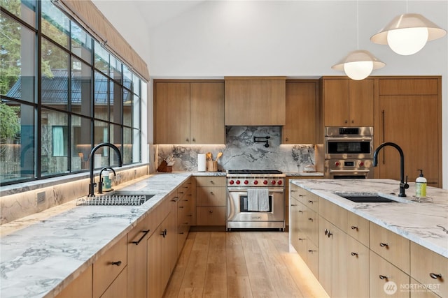 1501 Kokanee Loop, Cle Elum, WA 98922 - kitchen with appliances with stainless steel finishes, a sink, light stone countertops, backsplash, and vaulted ceiling