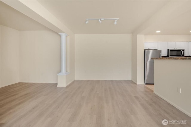 unfurnished living room with light wood-style floors, track lighting, recessed lighting, and ornate columns