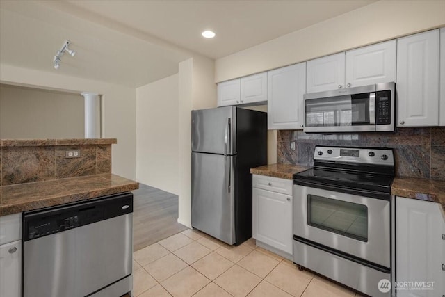 kitchen featuring stainless steel appliances, white cabinets, decorative backsplash, light tile patterned flooring, and recessed lighting