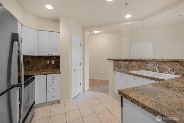 kitchen with freestanding refrigerator, electric range, white cabinets, backsplash, and recessed lighting