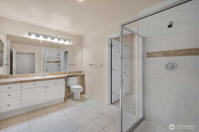 full bath with a stall shower, tile patterned floors, vanity, baseboards, and toilet