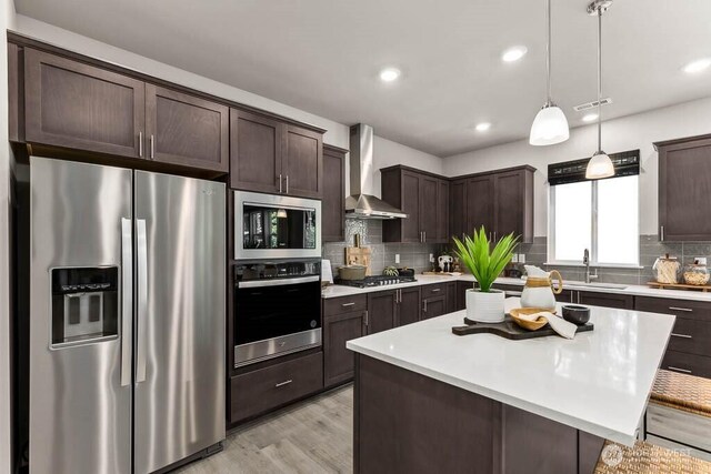 11434 SE 84th St Unit 34, Newcastle, WA 98056 - kitchen featuring stainless steel appliances, wall chimney range hood, dark brown cabinets, a sink, and light countertops