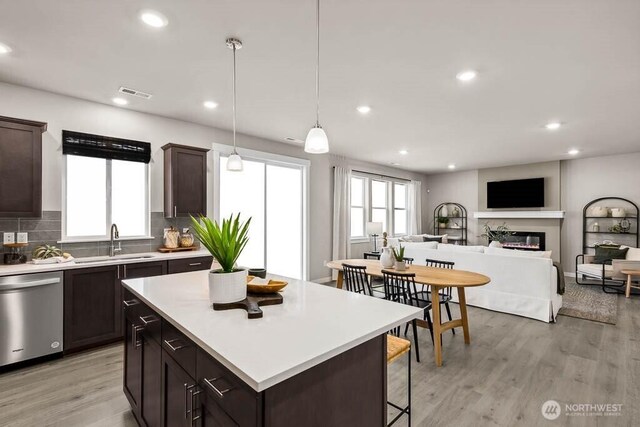 11434 SE 84th St Unit 34, Newcastle, WA 98056 - kitchen featuring a sink, stainless steel dishwasher, a glass covered fireplace, healthy amount of natural light, and recessed lighting