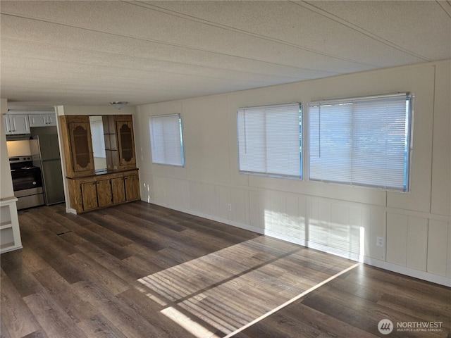 17925 Jordan St SW, Rochester, WA 98579 - unfurnished living room featuring dark wood finished floors, a decorative wall, and a textured ceiling