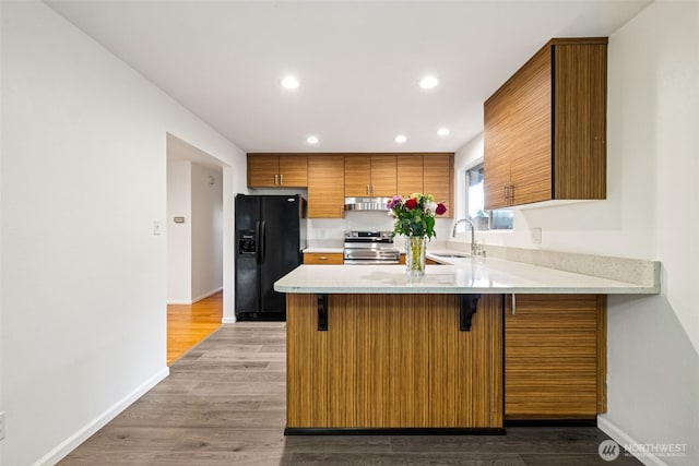 35010 45th Ave S, Auburn, WA 98001 - kitchen with black fridge with ice dispenser, stainless steel range with electric stovetop, a sink, brown cabinets, and a peninsula