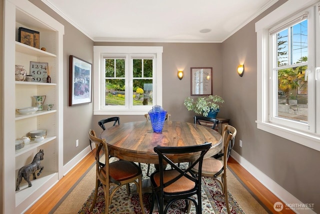 1712 Arch Ave SW, Seattle, WA 98116 - dining area featuring light wood-style flooring, ornamental molding, baseboards, and built in features